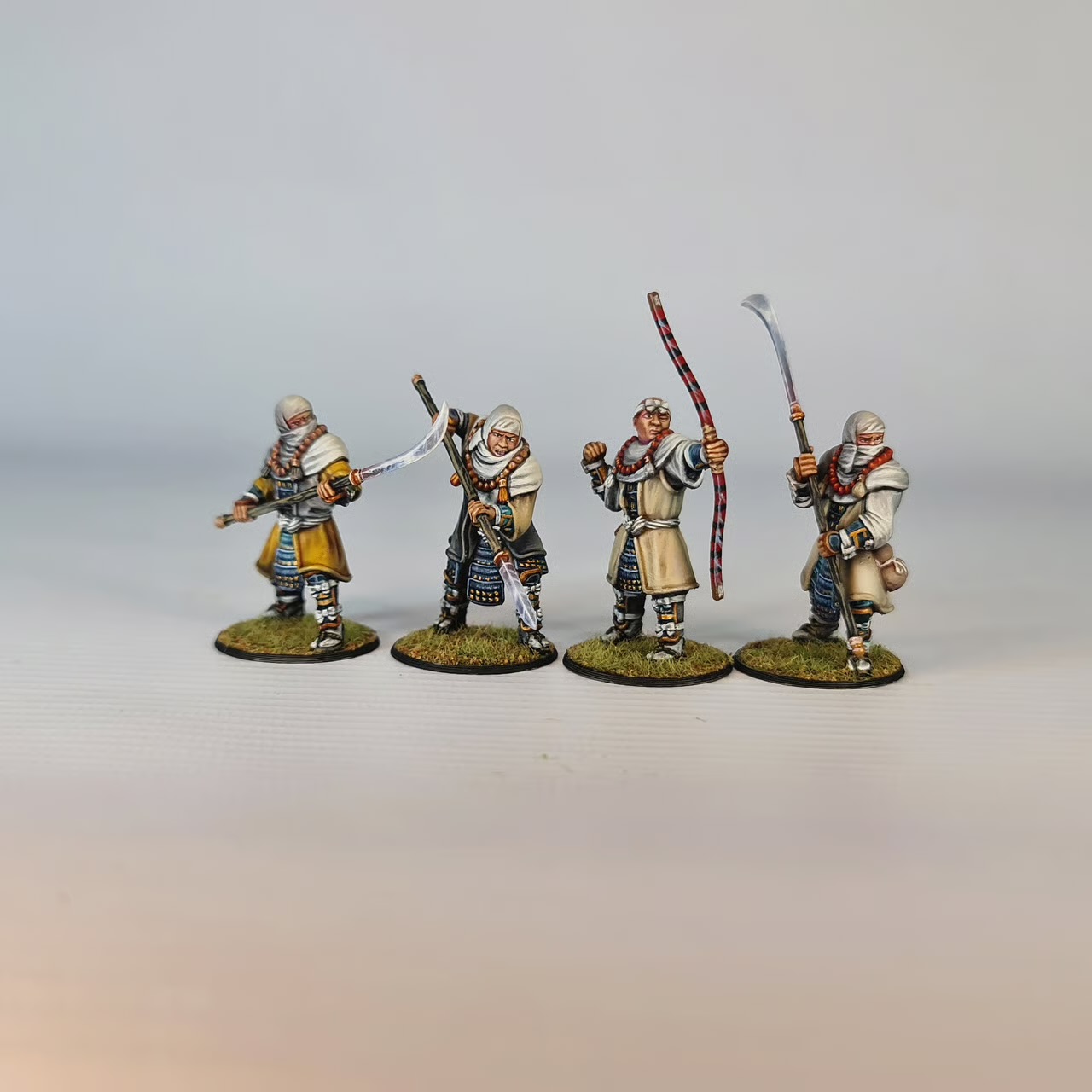 Vier bemalte Ikko-Ikki-Mönche mit Naginata und Bogen